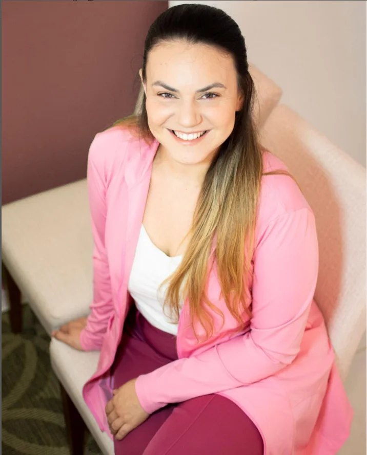 Dra. Andréia Silva, fisioterapeuta e osteopata, sorrindo, sentada em uma poltrona